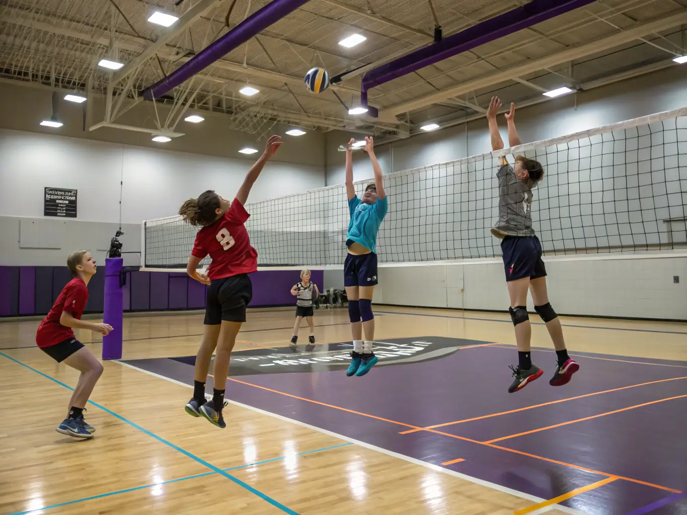 A dynamic action shot of a youth volleyball team practicing drills on the court, focusing on teamwork and skill development, set in a brightly lit gymnasium.